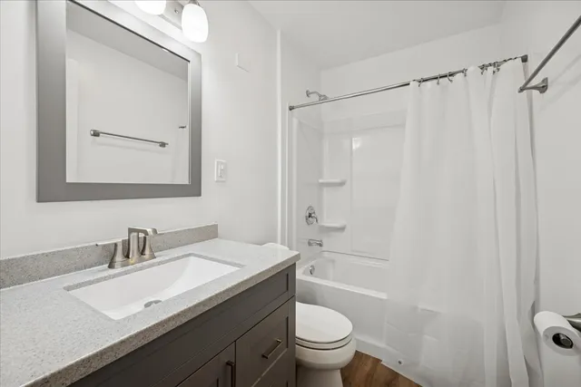 a bathroom with a granite countertop sink toilet and shower