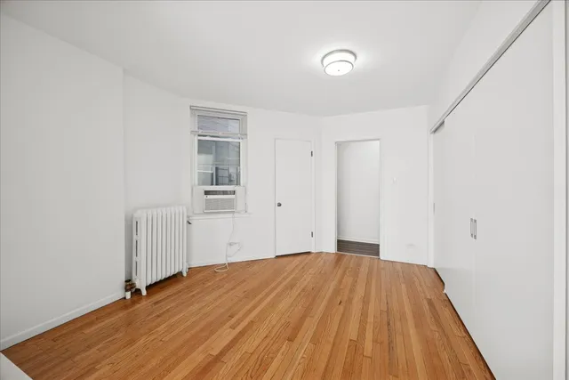 a view of a room with wooden floor and white walls