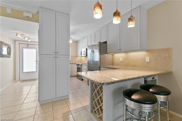 a kitchen with stainless steel appliances granite countertop a sink and a refrigerator