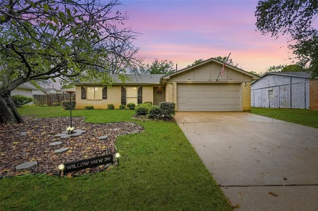 a front view of a house with a garden and yard