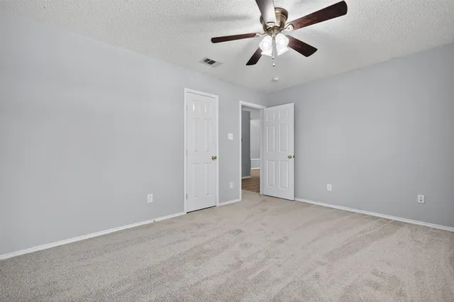 an empty room with chandelier fan