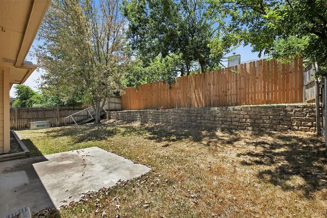 a view of backyard with wooden fence