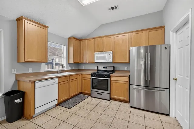 a kitchen with stainless steel appliances granite countertop a refrigerator sink and cabinets