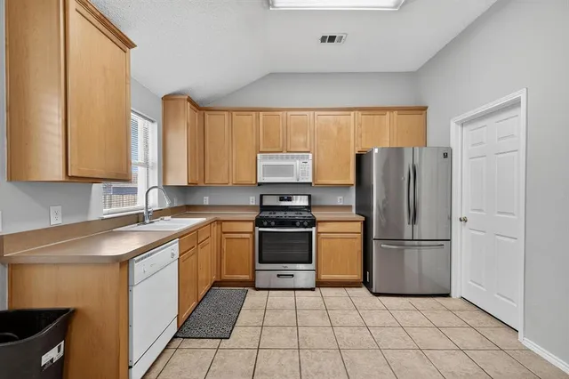 a kitchen with stainless steel appliances granite countertop a refrigerator and a sink