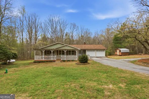 a view of an empty room with wooden floor and a fireplace