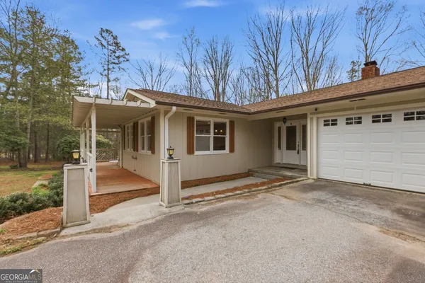 a front view of a house with a yard and trees