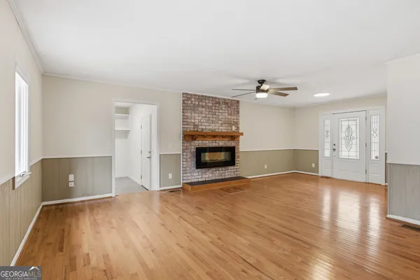 a view of a livingroom with wooden floor and a fireplace