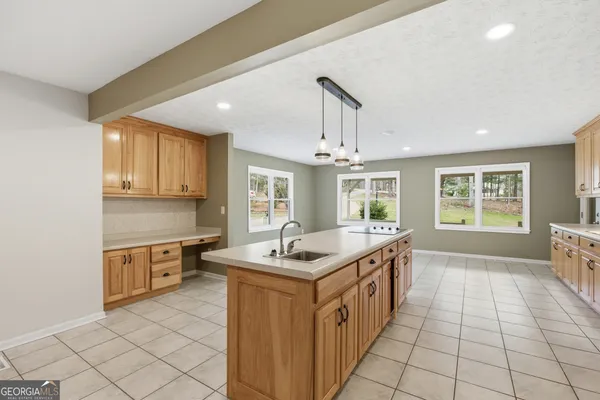 an empty room with wooden floor chandelier fan and windows