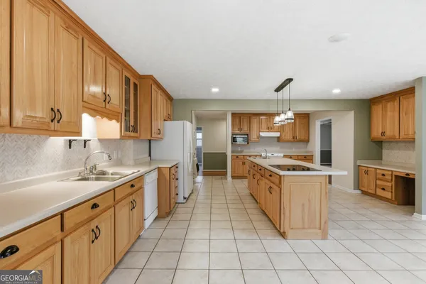 a large kitchen with stainless steel appliances granite countertop a sink and cabinets
