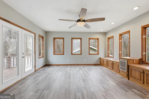 a view of an empty room with wooden floor and a window