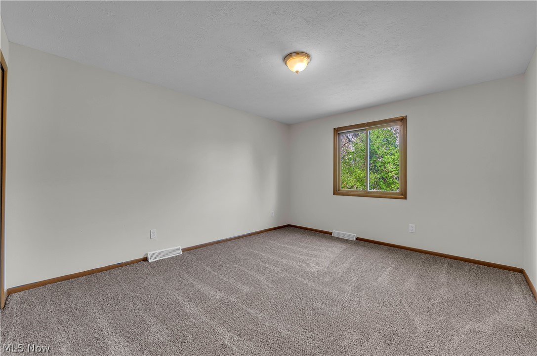 2540 Charney Road University Heights, OH 44118 - Photo 26 of 44 Carpeted room featuring light gray walls, a single window with wood-finish trim, and a semi-flush mount ceiling light fixture