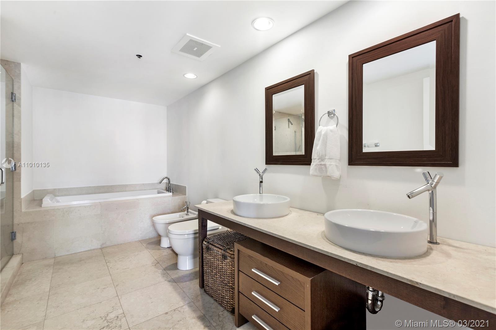 495 Brickell Avenue, Unit 1802 Miami, FL 33131 - Photo 13 of 29 a bathroom with a double vanity sink a toilet and a bathtub
