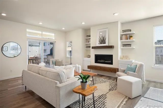 a living room with furniture a fireplace and a large window