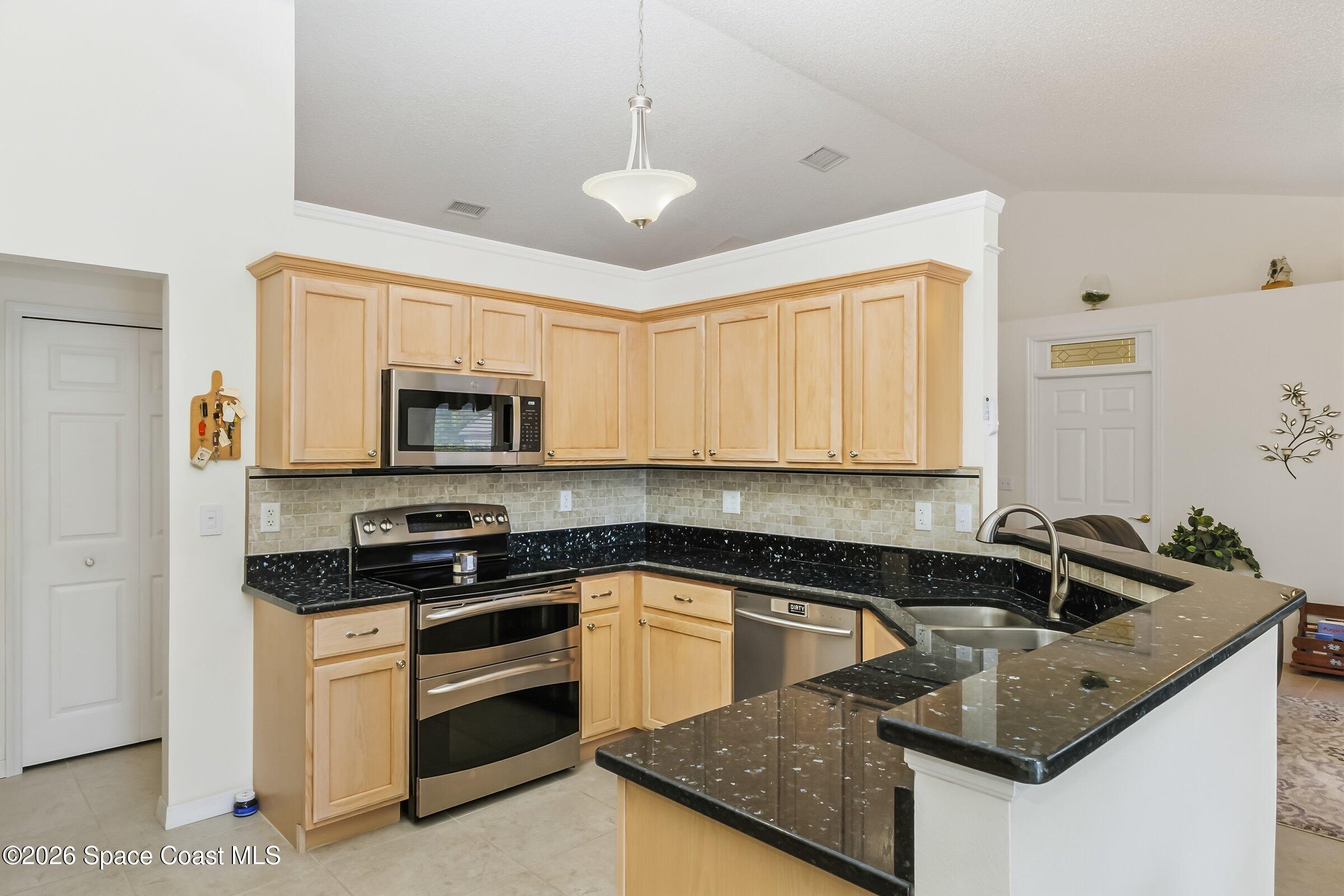 263 Mcclain Drive Melbourne, FL 32904 - Photo 13 of 56 a kitchen that has a sink and a stove