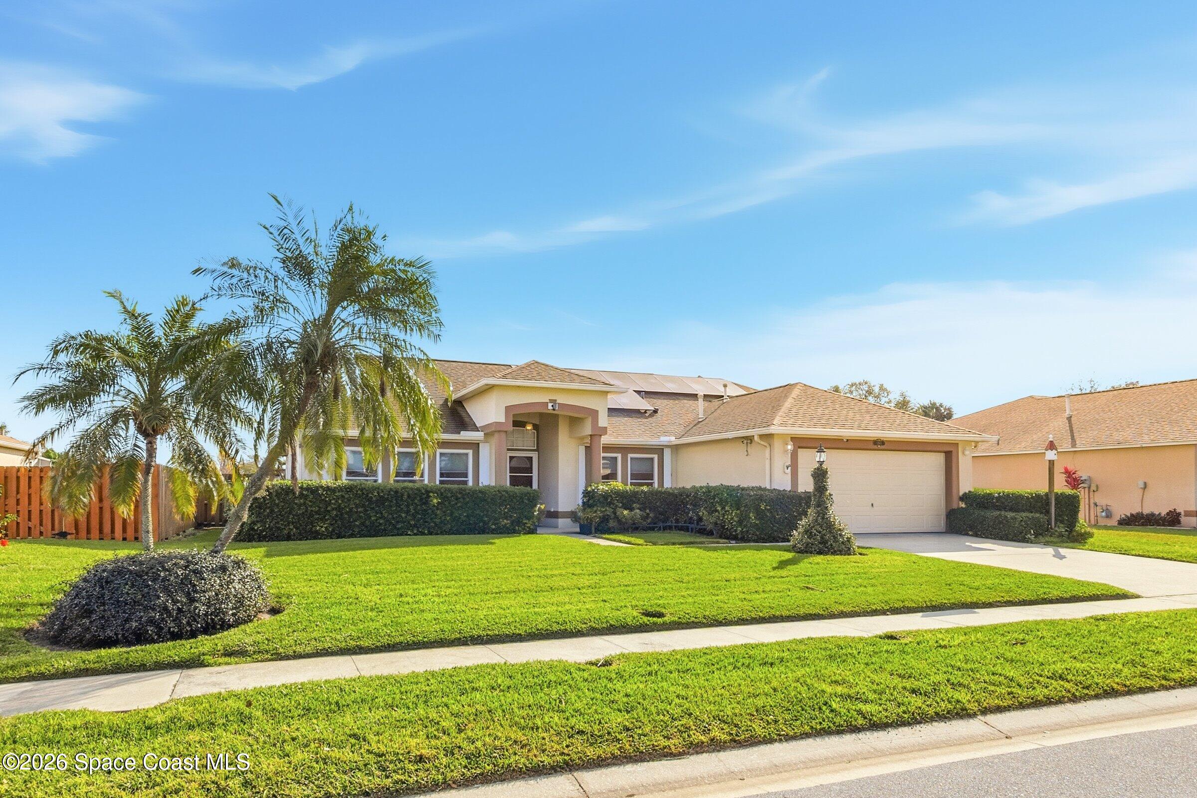 263 Mcclain Drive Melbourne, FL 32904 - Photo 3 of 56 a front view of a house with a yard and garage