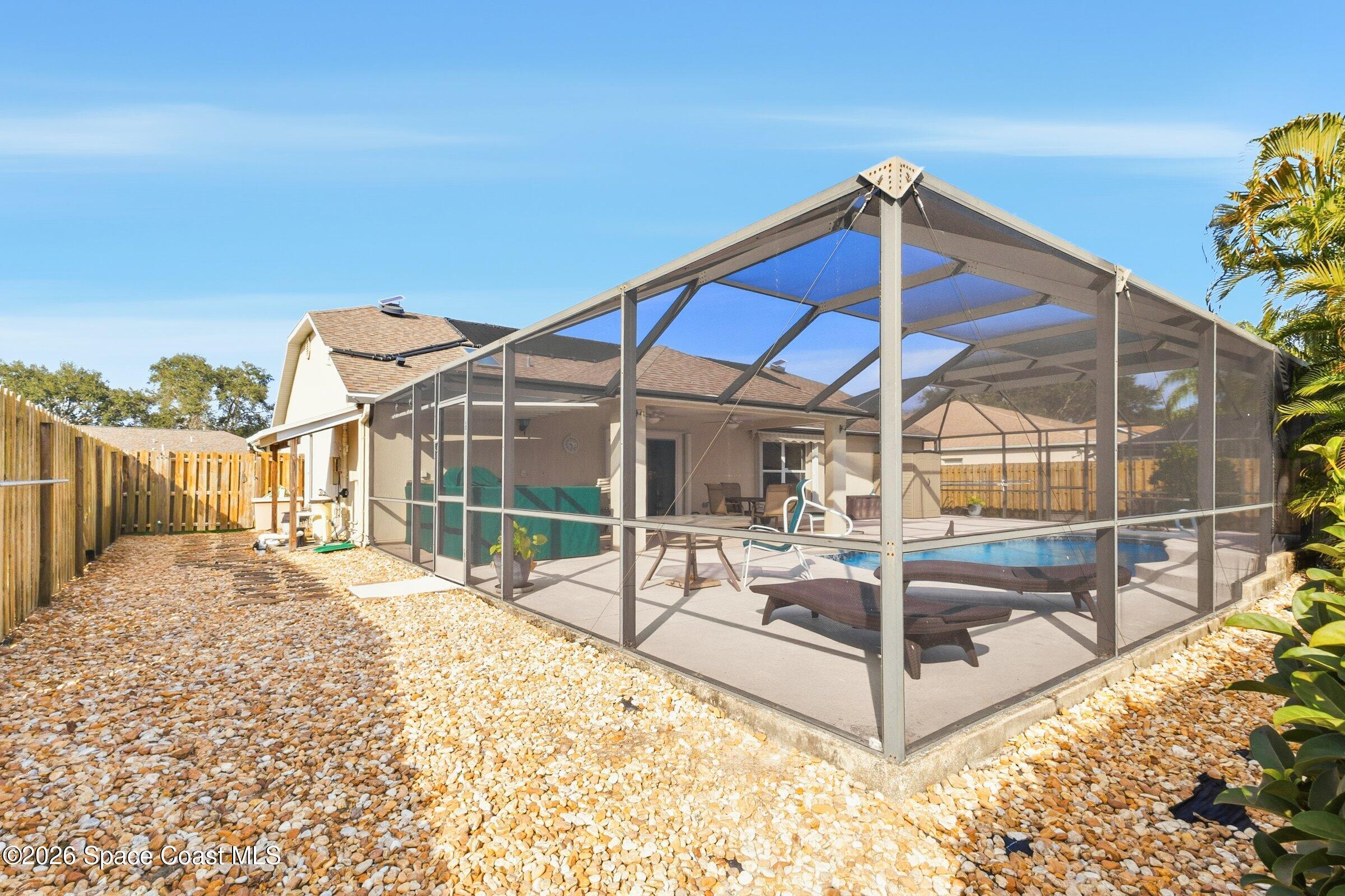 263 Mcclain Drive Melbourne, FL 32904 - Photo 38 of 56 a view of a house with a small yard and wooden fence