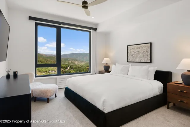 a large bedroom with a bed and a large window