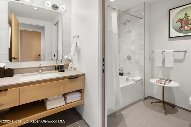 a bathroom with a double vanity sink mirror and bathtub
