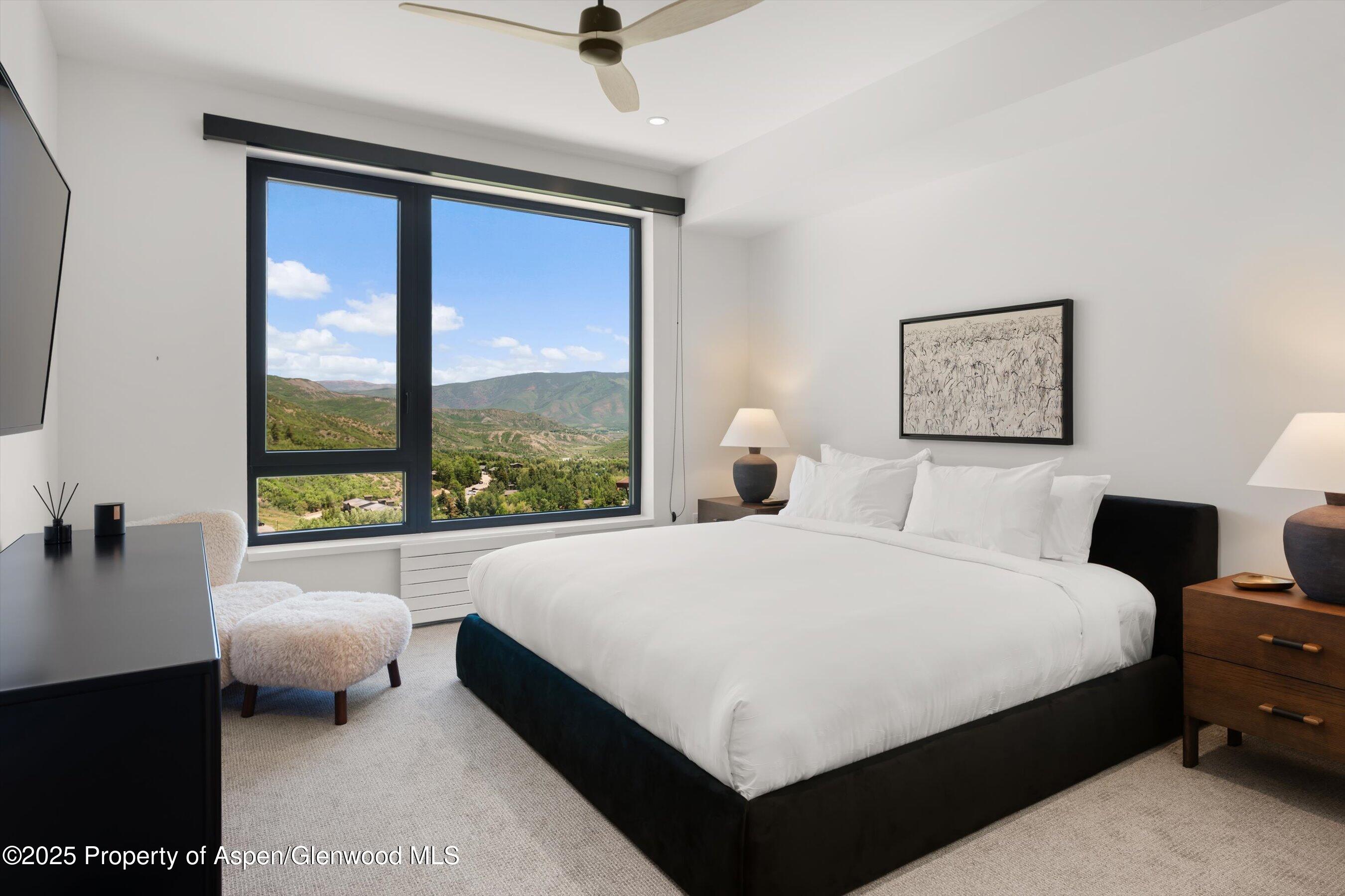 119 Wood Road, Unit 604 Snowmass Village, CO 81615 - Photo 21 of 48 a large bedroom with a bed and a large window