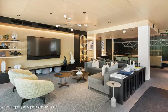 a living room with furniture a flat screen tv and a floor to ceiling window