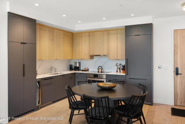 a kitchen with a sink a stove a refrigerator cabinets and dining table