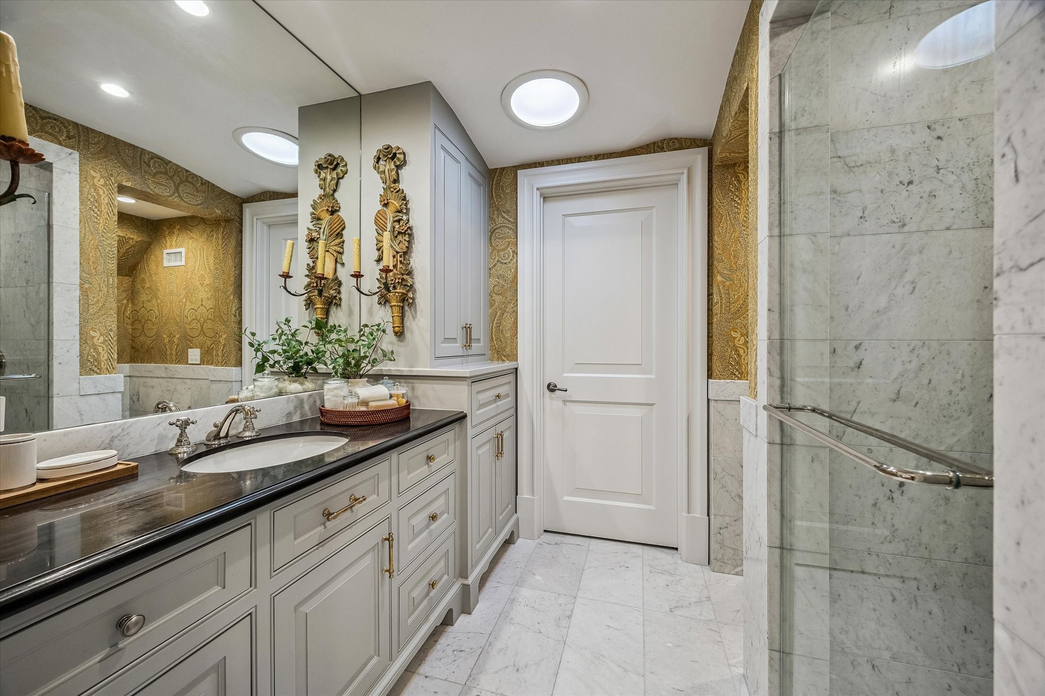 2158 Chilton Road Houston, TX 77019 - Photo 48 of 50 The ensuite bathroom No 4exudes sophistication with marble floors and wainscoting, a walk-in shower with bench seating, and polished nickel fixtures. Designer wallpaper and high-end finishes complete this luxurious, spa-inspired space.