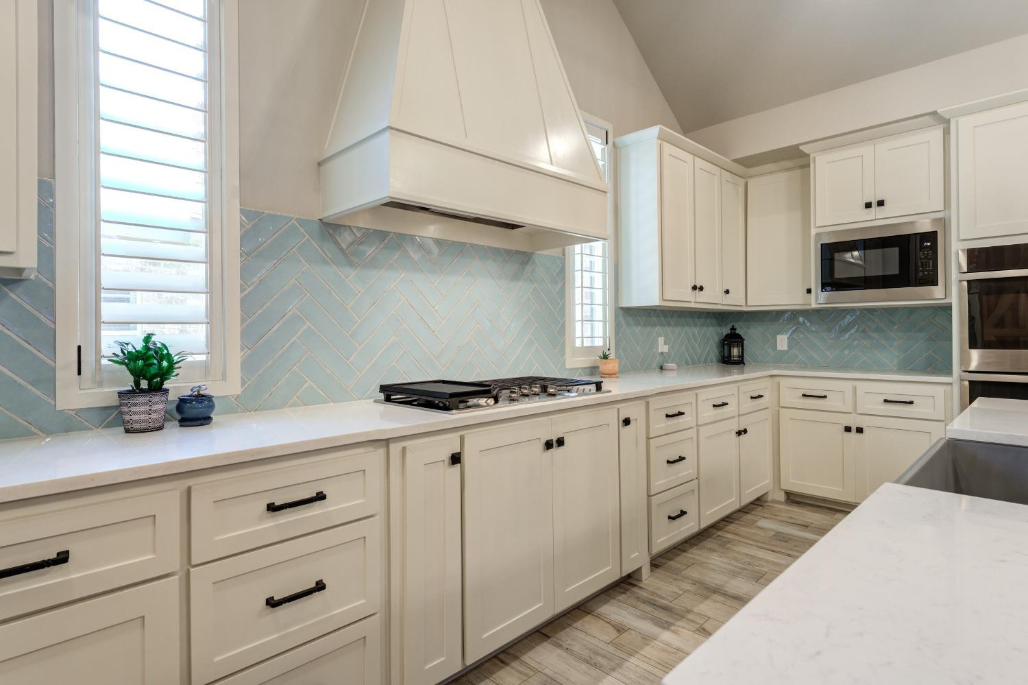 4908 109th Place Lubbock, TX 79424 - Photo 7 of 44 a kitchen with granite countertop white cabinets and stainless steel appliances