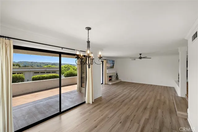 a view of empty room with wooden floor and windows