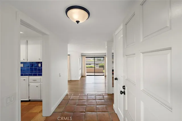 a view of a hallway with wooden floor and a cabinet