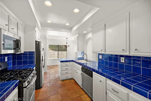 a kitchen with stainless steel appliances a stove a sink and a microwave