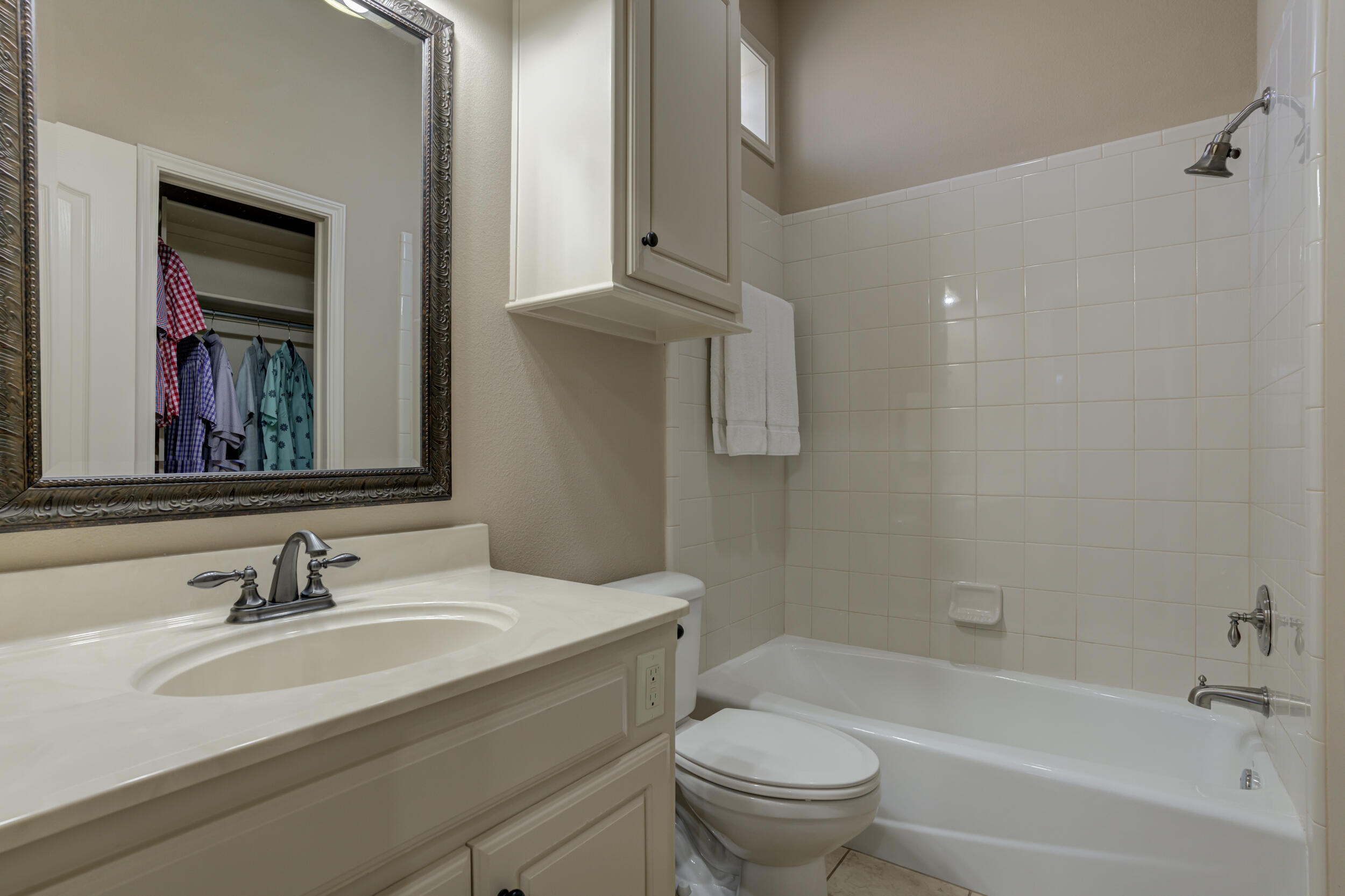 6008 89th Street Lubbock, TX 79424 - Photo 42 of 61 a bathroom with a granite countertop sink a toilet and bathtub