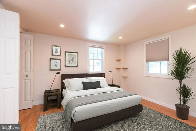 a bedroom with a large bed and a potted plant