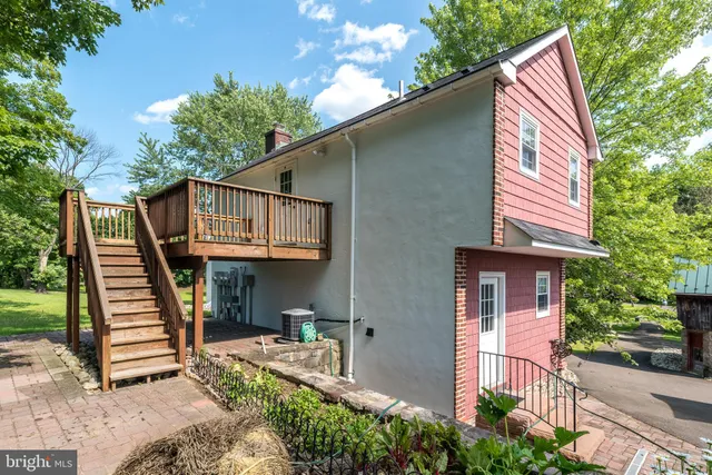 a view of a house with wooden stairs and a small yard