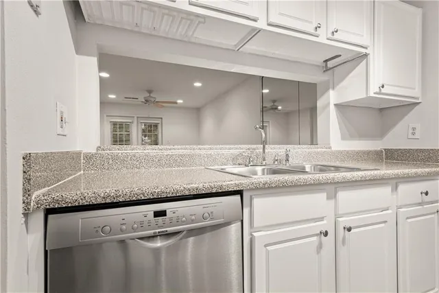 a kitchen with granite countertop a sink and cabinets