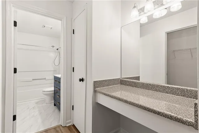 a bathroom with a granite countertop sink and a mirror