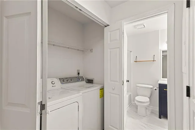 a bathroom with a granite countertop toilet and a sink