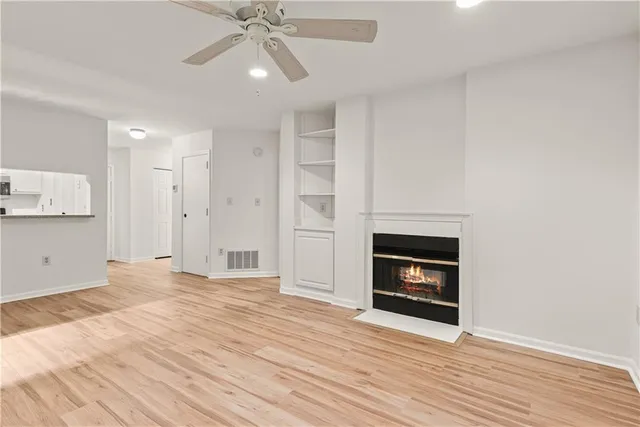 a view of an empty room with a fireplace and a window