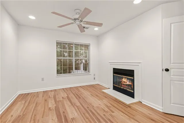 wooden floor fireplace and windows in an empty room