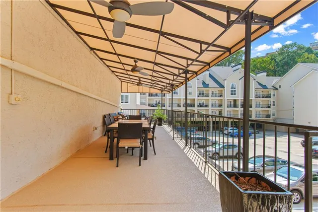 a view of a balcony with chairs and iron fence
