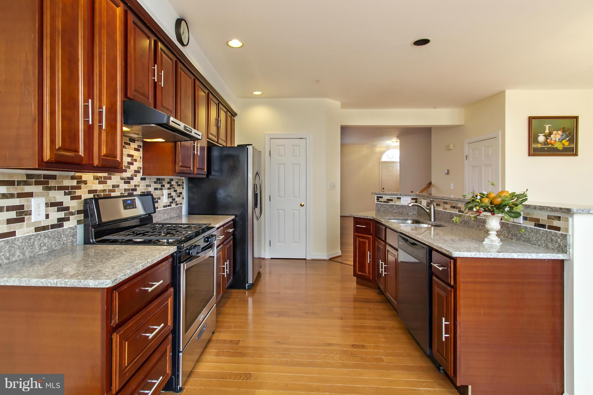 a kitchen with stainless steel appliances granite countertop a stove a sink dishwasher and a refrigerator