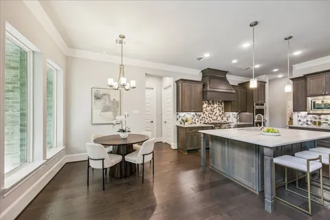 a kitchen with kitchen island a sink dining table and chairs