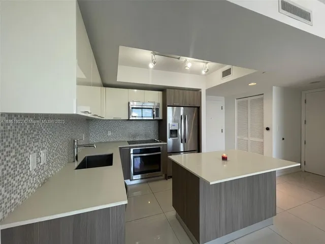 a kitchen with stainless steel appliances a sink stove and refrigerator