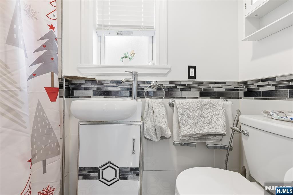 42 South Demarest Avenue Bergenfield, NJ 07621 - Photo 13 of 39 a bathroom with a toilet sink and mirror