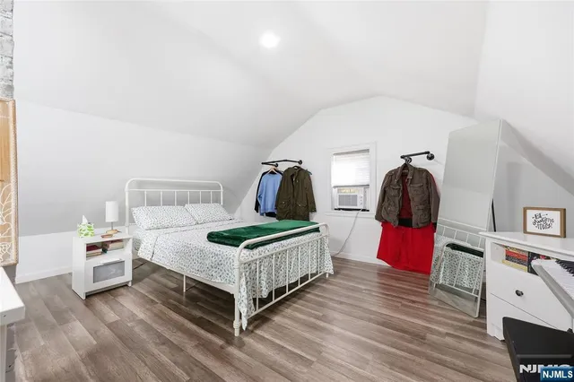 a bedroom with a bed and a flat tv screen on the dresser