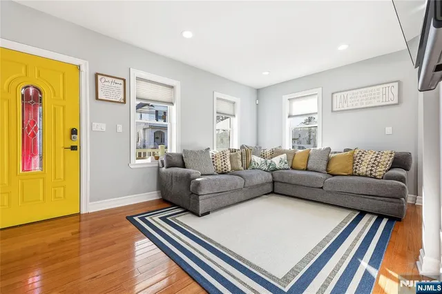 a living room with furniture and a wooden floor