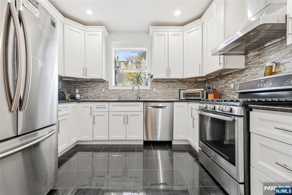 42 South Demarest Avenue Bergenfield, NJ 07621 - Photo 8 of 39 a kitchen with granite countertop a sink stainless steel appliances and cabinets