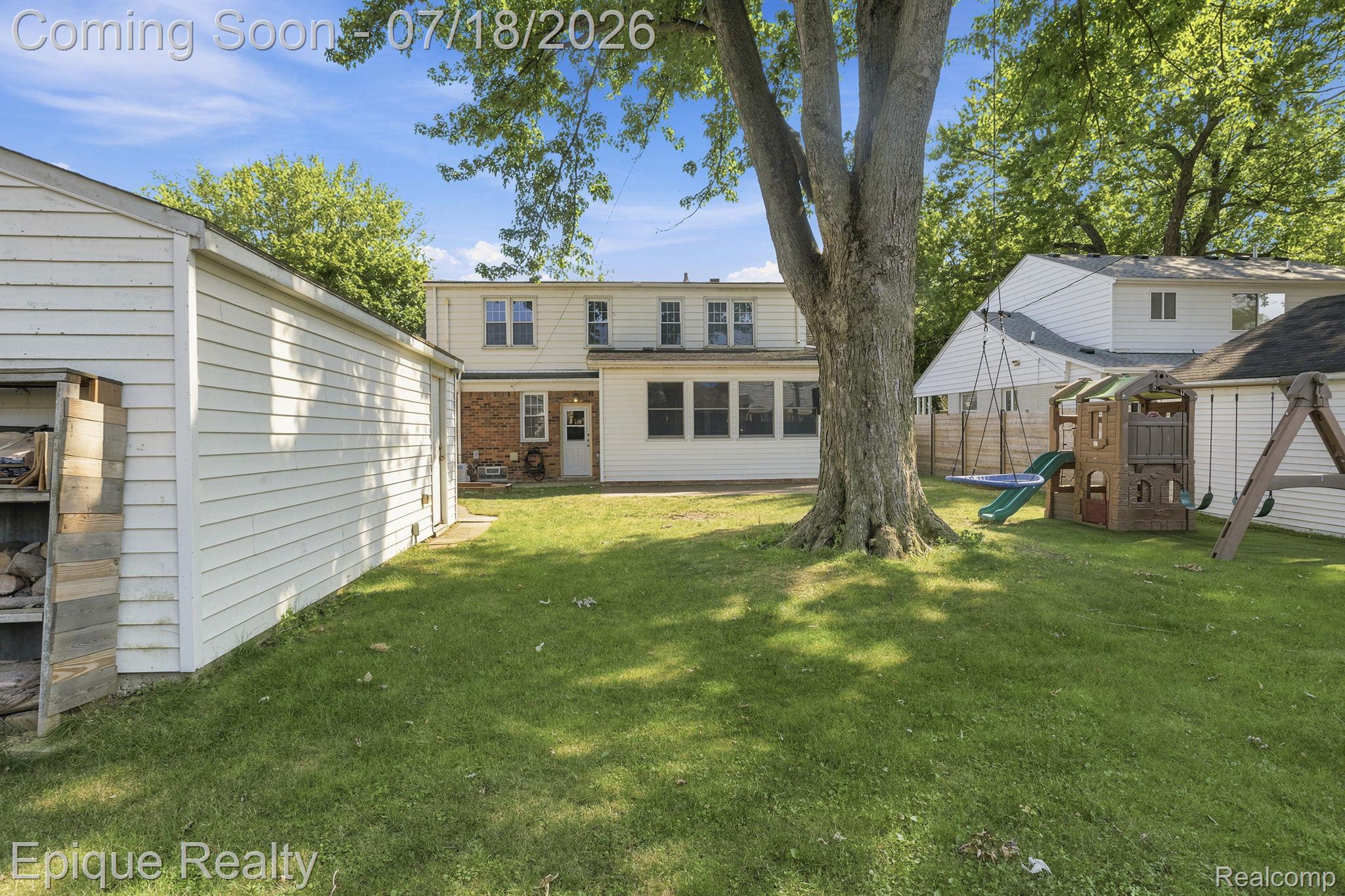 1206 Hawthorne Road Grosse Pointe, MI 48236 - Photo 25 of 28 Expansive rear yard featuring a large mature tree, a detached garage with siding, and an additional storage rack