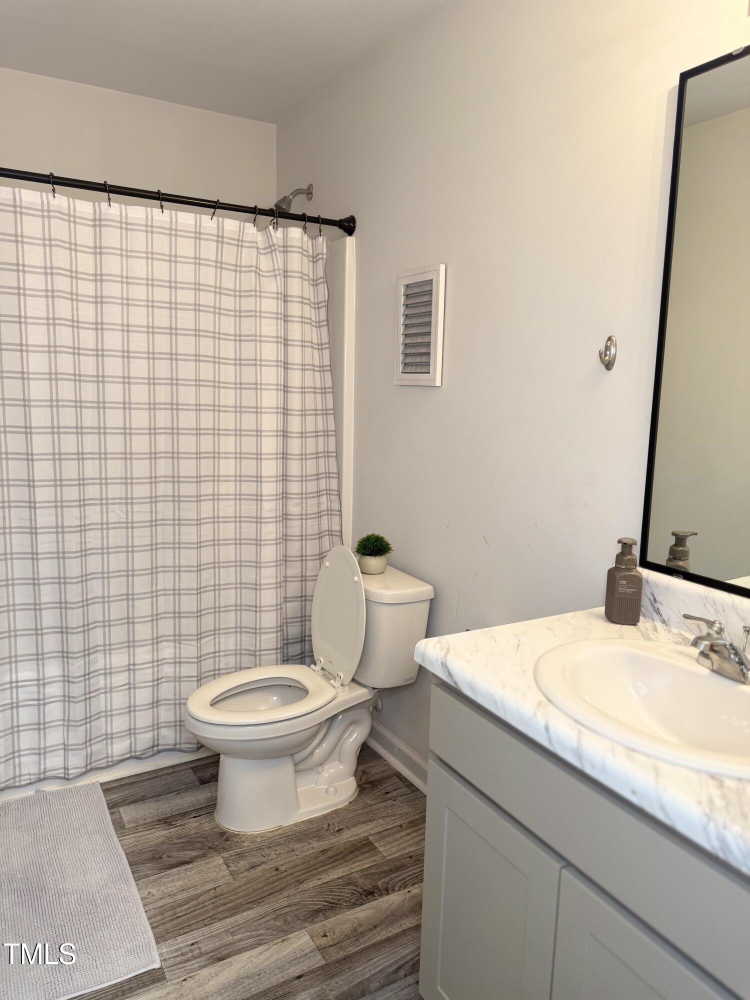 150 Riley Way Spring Hope, NC 27882 - Photo 11 of 27 a bathroom with a granite countertop toilet a sink and a mirror