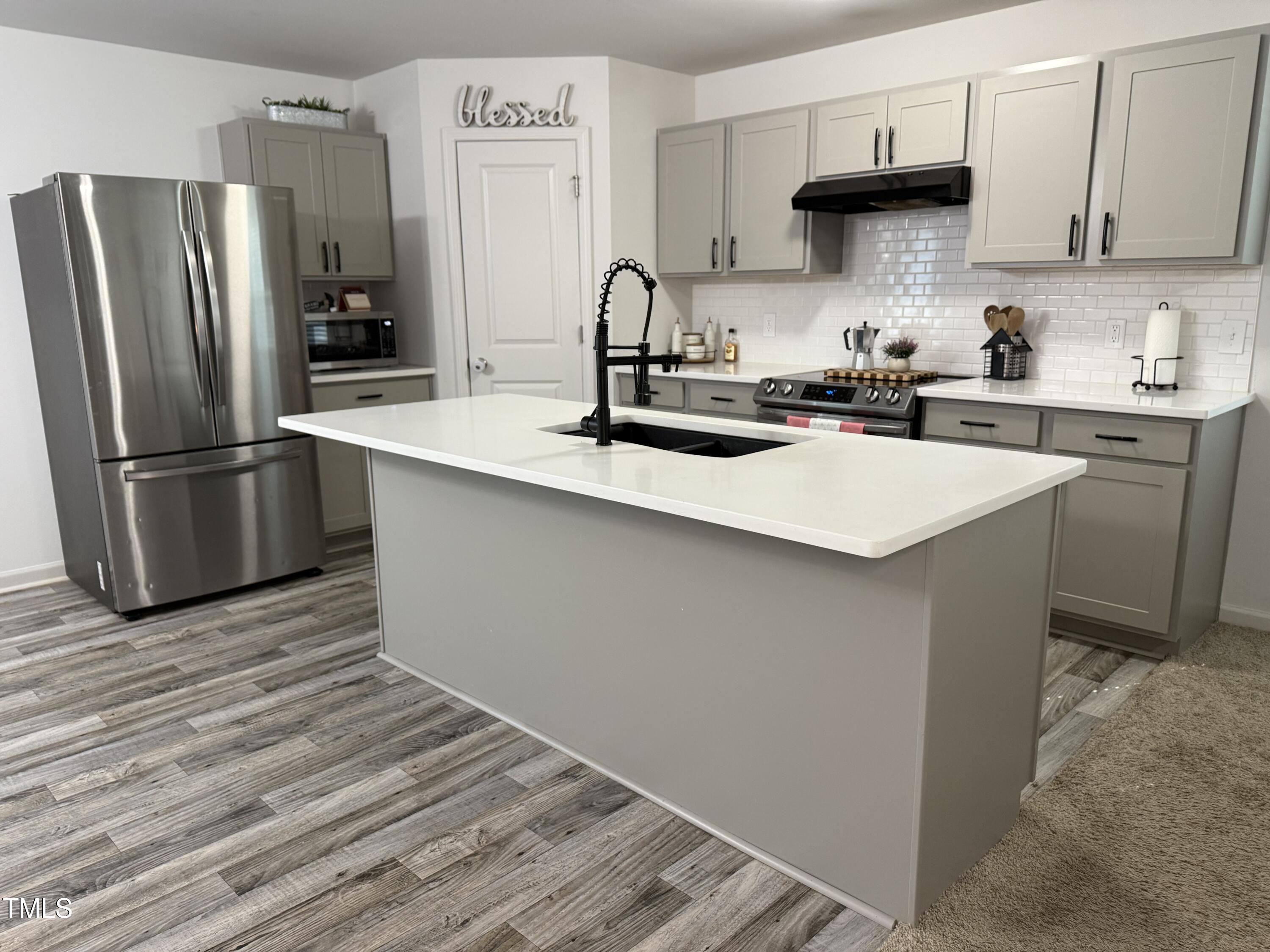 150 Riley Way Spring Hope, NC 27882 - Photo 3 of 27 a kitchen with stainless steel appliances a sink a stove a refrigerator and cabinets