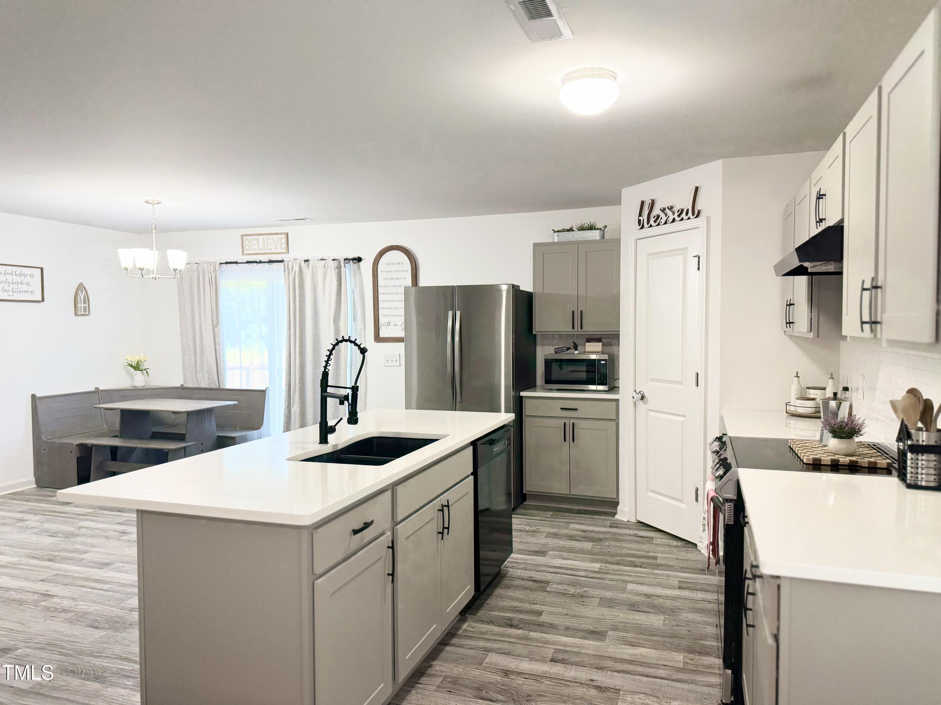 150 Riley Way Spring Hope, NC 27882 - Photo 7 of 27 a kitchen with white cabinets and stainless steel appliances